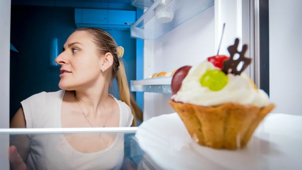 Closeup portrait of woman sneaking in refrigerator for something to eat