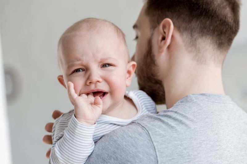 My Child Is Having Trouble Sleeping: Father Holding Crying Baby